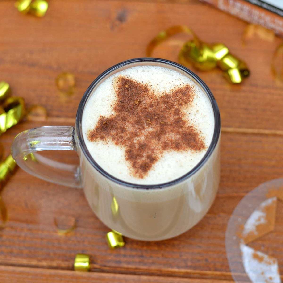 Latte with a star shaped cinnamon stenciled into the frothy milk.
