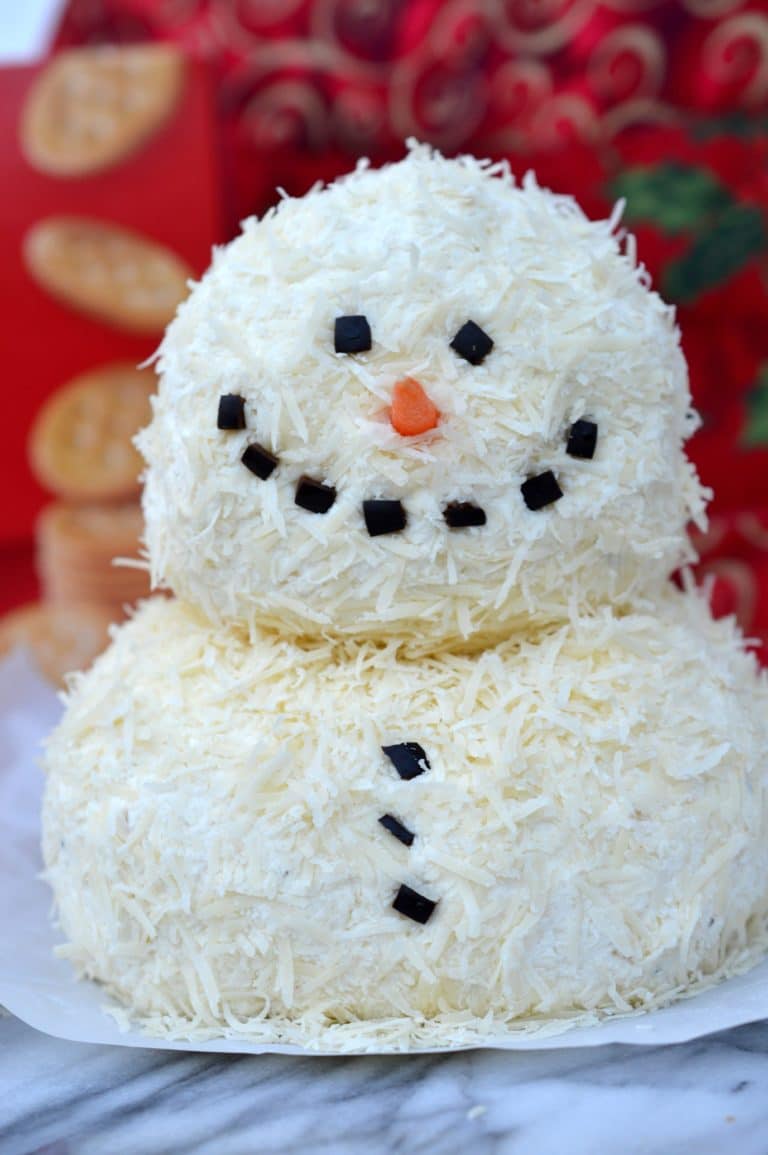 This savory Garlic Parmesan Holiday Snowman Cheeseball contains minimal ingredients and is SO impressive on a holiday platter! Dress up your appetizer spread with something new and festive this holiday season!