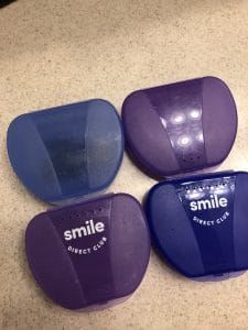4 SmileDirectClub retainer cases on a counter.