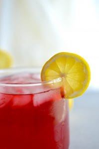 Passion Tea Lemonade in a short glass with a lemon slice on the rim.