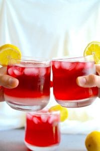 Two people "cheers-ing" to summer with their glasses of Passion Tea Lemonade.