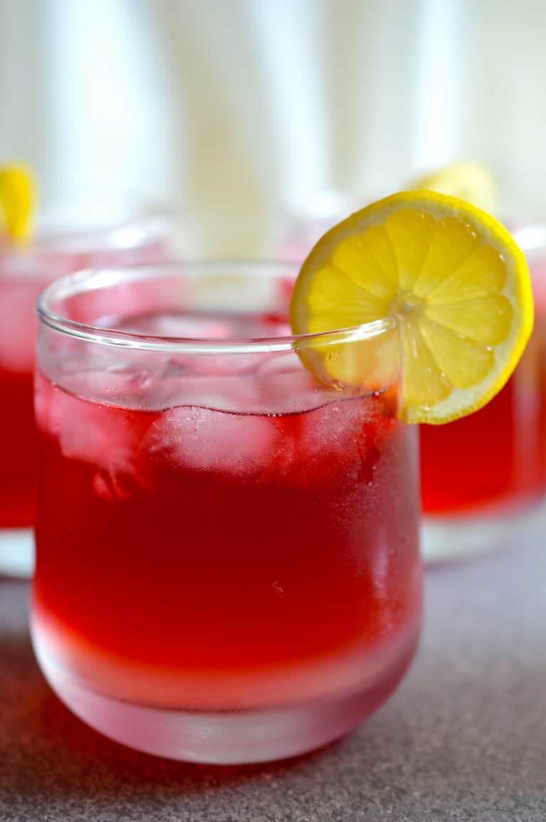 Passion Tea Lemonade in a glass with lemon slice on the rim of the glass.