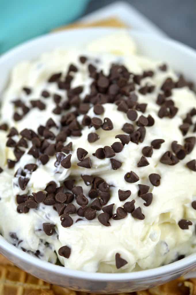 Cannoli dip topped with mini chocolate chips in a bowl.