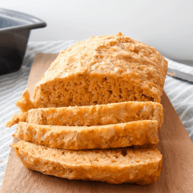Cheddar garlic beer bread on a cutting board, sliced.