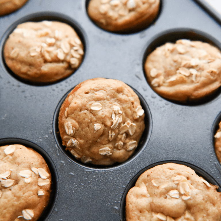 Apple Cinnamon Oatmeal Muffins sprinkled with old fashioned oats in a muffin pan.